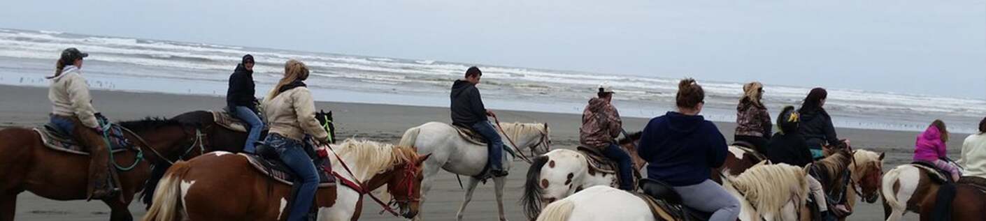 Horseback riders traveling along the Pacific Ocean beach